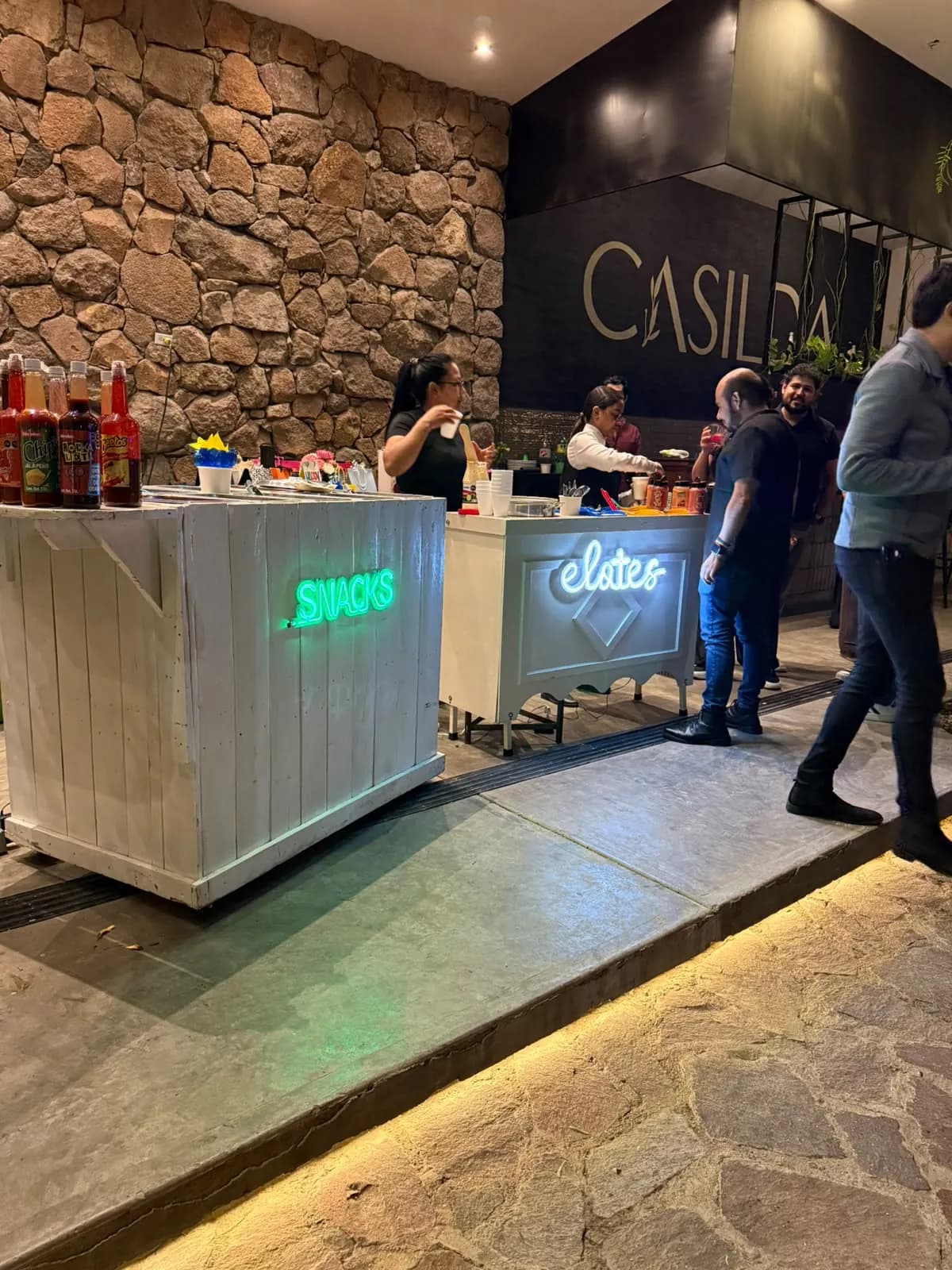 Carritos de madera de snacks y elotes con letreros de neón
