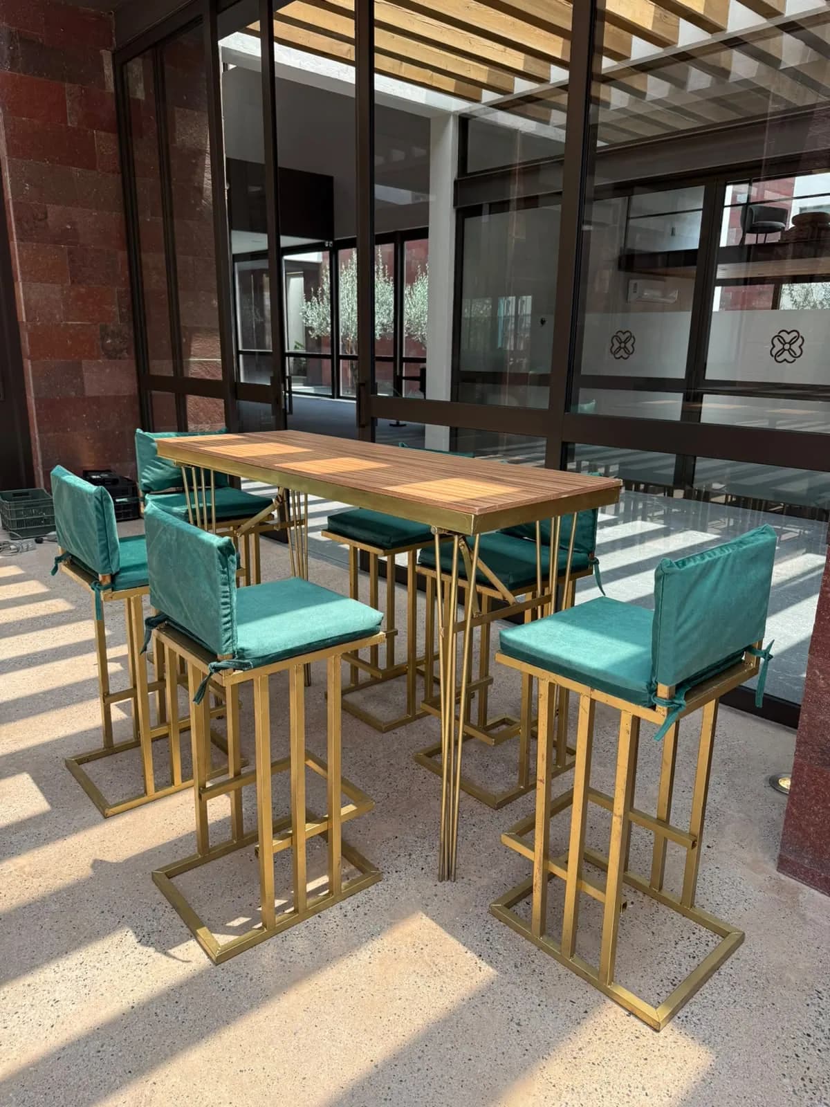 Periqueras de madera con bancos dorados y cojines turquesa