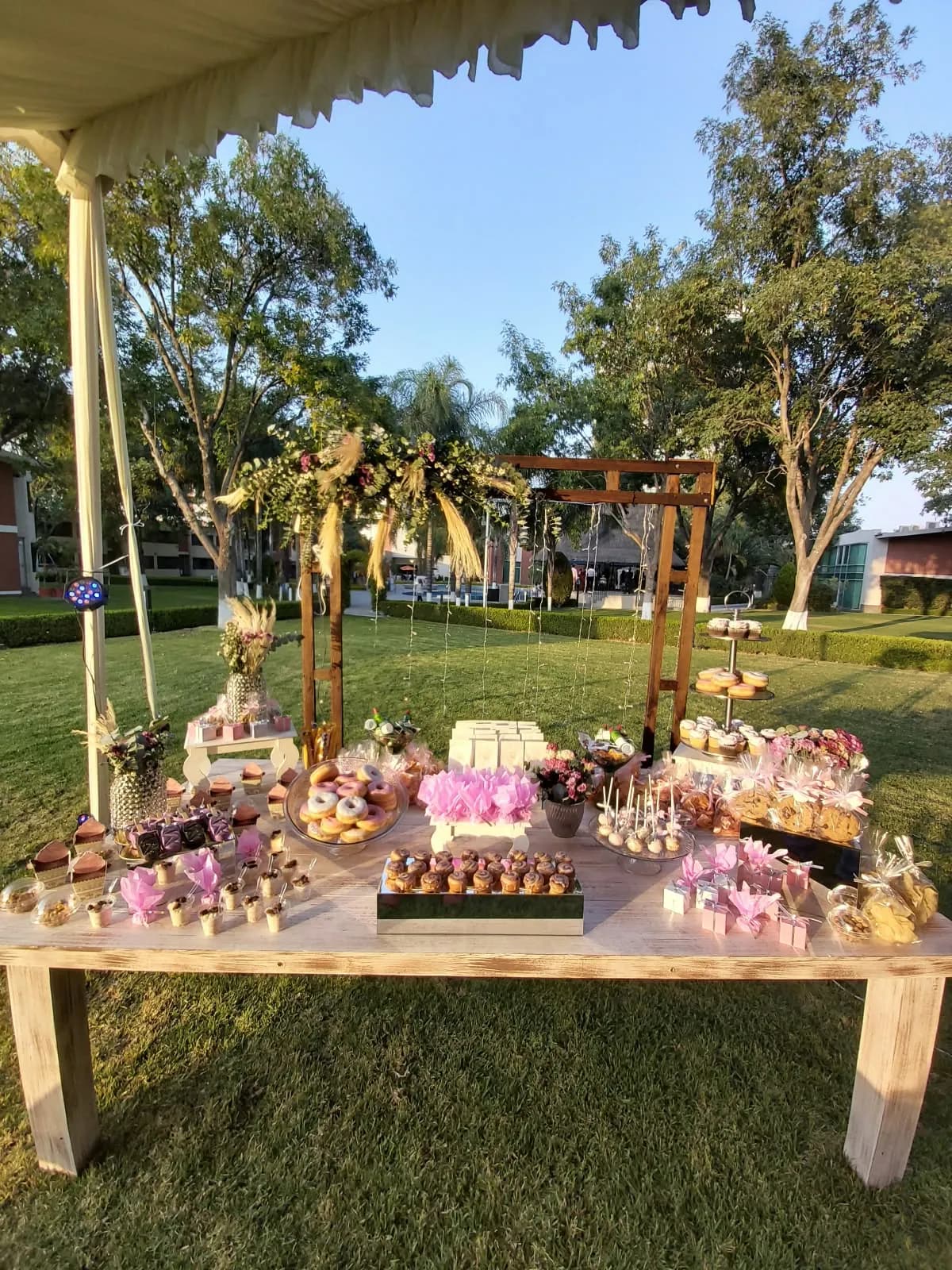 Mesa de postres en un jardín al atardecer