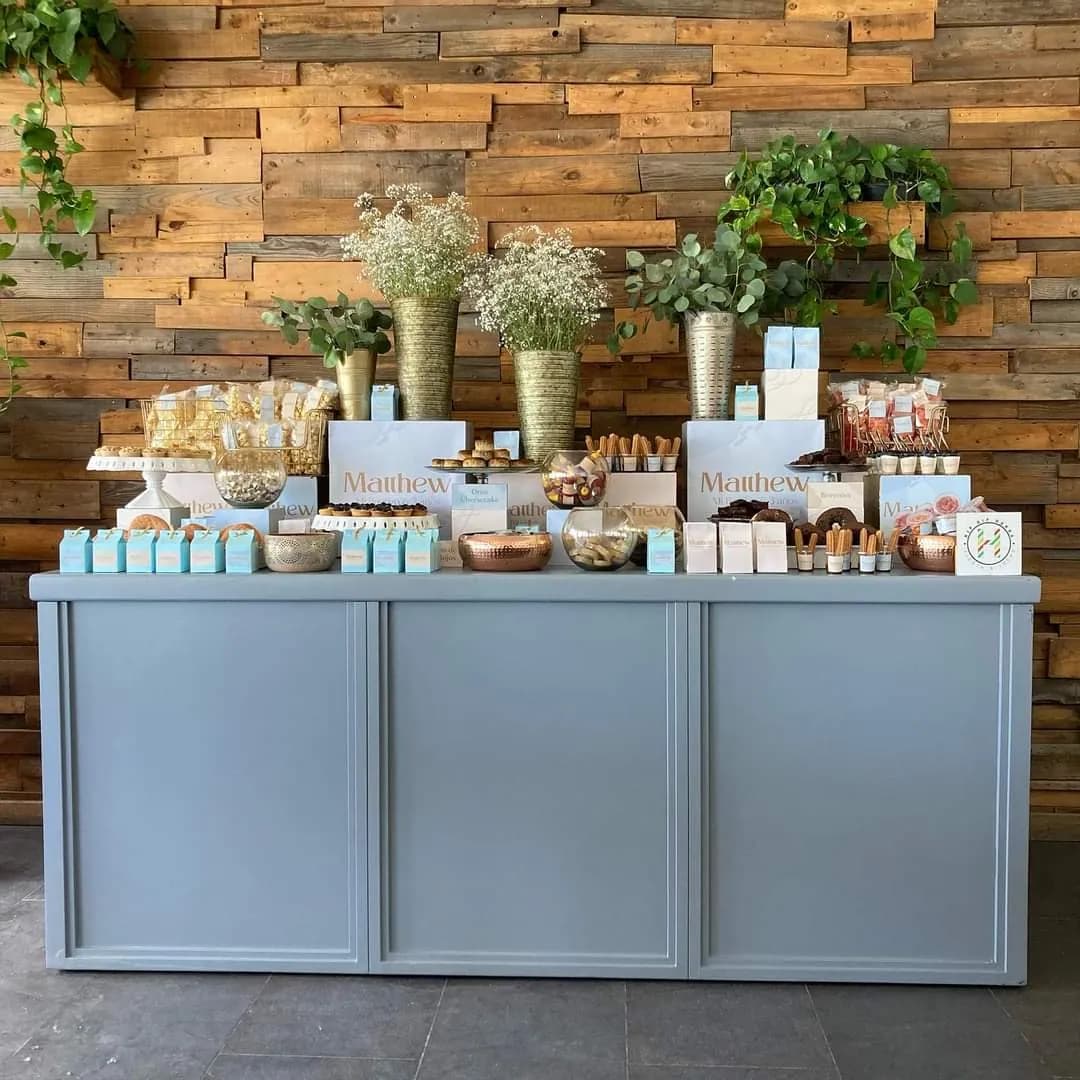 Mesa de dulces frente a un muro de madera